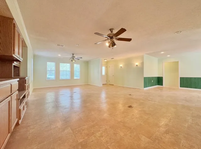 a kitchen with stainless steel appliances granite countertop a refrigerator a sink dishwasher a stove and white countertops with wooden floor