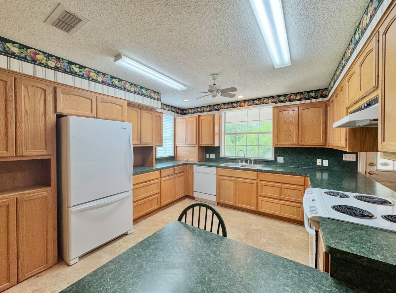 608 Mogonye Lane Elgin, TX 78621 - Photo 10 of 38 a kitchen with stainless steel appliances granite countertop a refrigerator a sink dishwasher a stove and white countertops with wooden floor