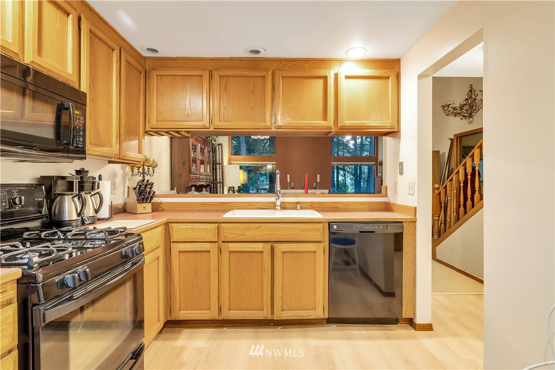 25419 213th Place Southeast, Unit 60 Maple Valley, WA 98038 - Photo 12 of 27 a kitchen with stainless steel appliances granite countertop a stove and a sink