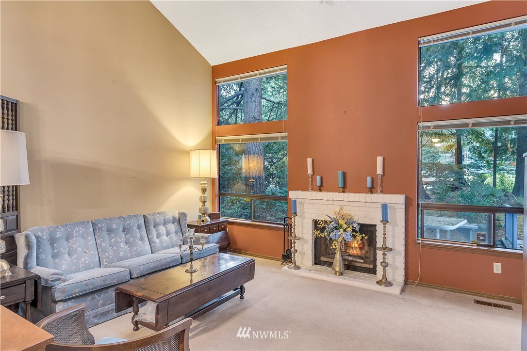 25419 213th Place Southeast, Unit 60 Maple Valley, WA 98038 - Photo 8 of 27 a living room with furniture a floor to ceiling window and a fireplace