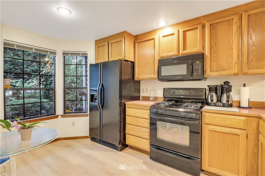 25419 213th Place Southeast, Unit 60 Maple Valley, WA 98038 - Photo 10 of 27 a kitchen with a stove a sink and a refrigerator