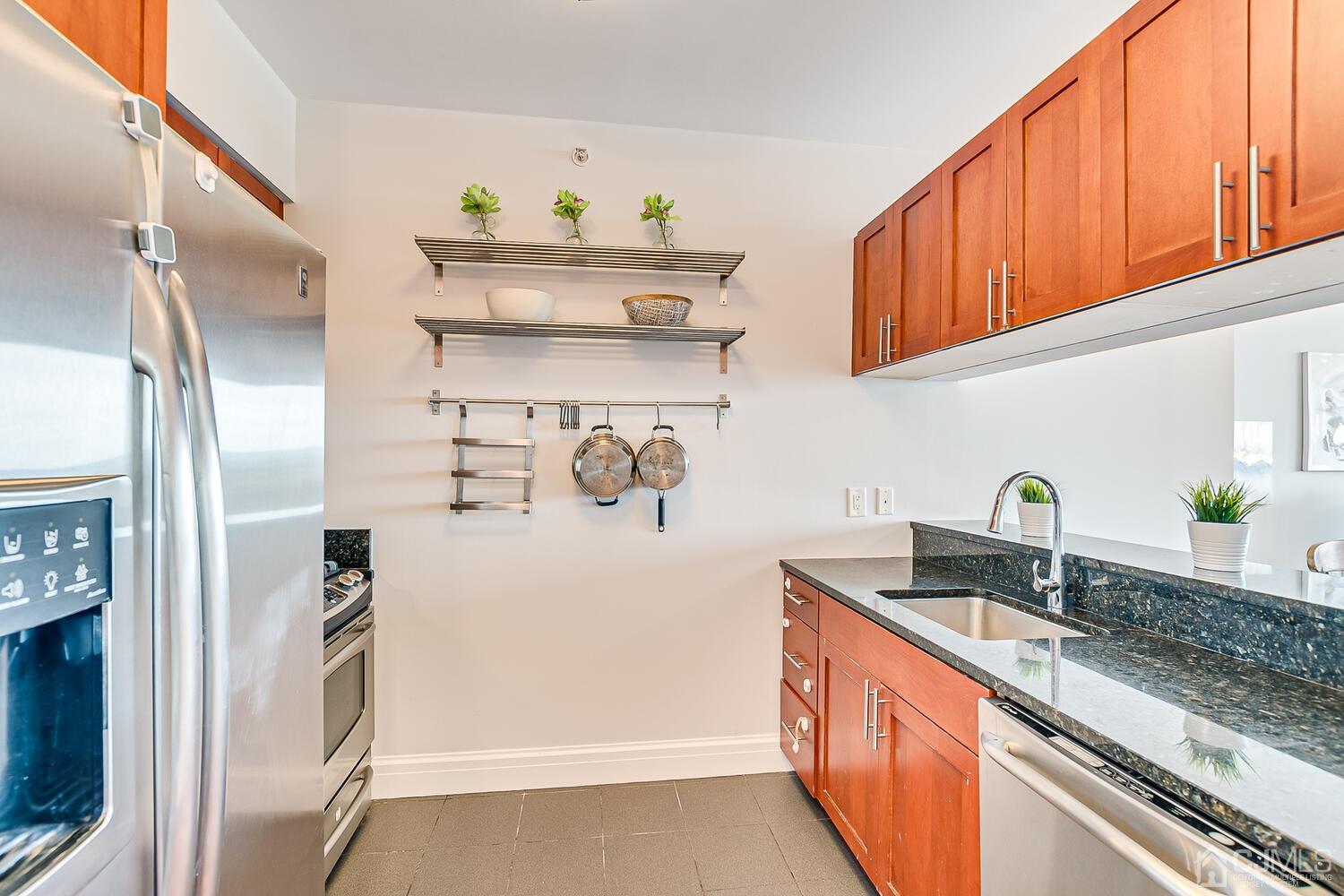 1 Spring Street, Unit 1806 New Brunswick, NJ 08901 - Photo 11 of 57 a kitchen with stainless steel appliances granite countertop a sink and a refrigerator