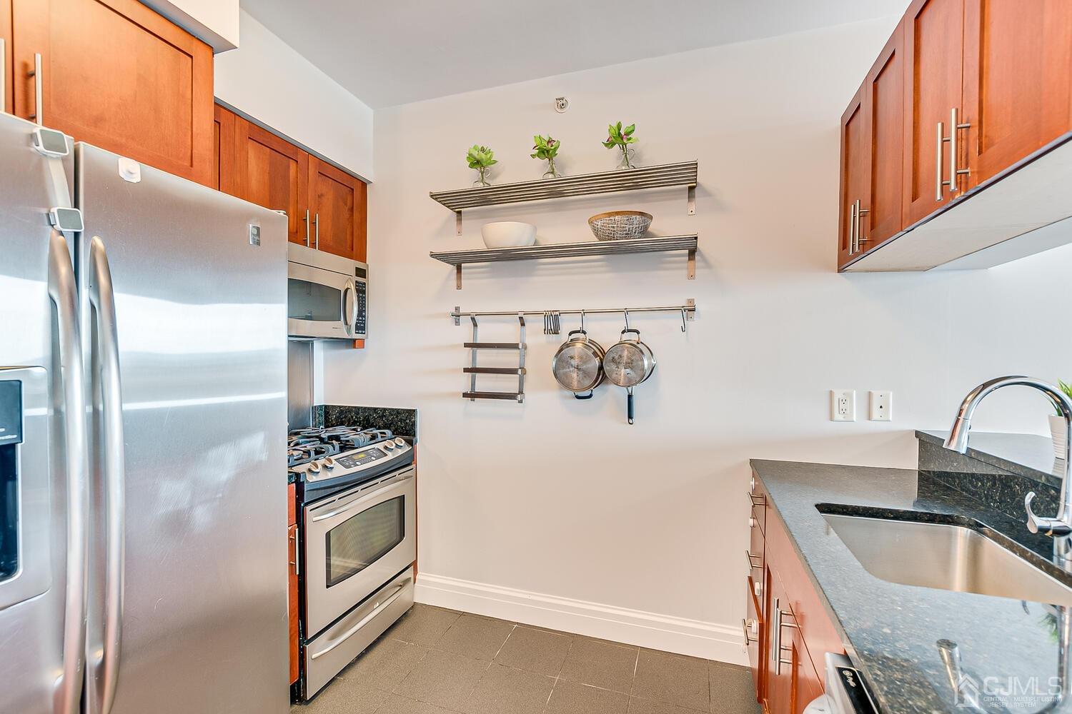 1 Spring Street, Unit 1806 New Brunswick, NJ 08901 - Photo 12 of 57 a kitchen with stainless steel appliances granite countertop a refrigerator and a sink