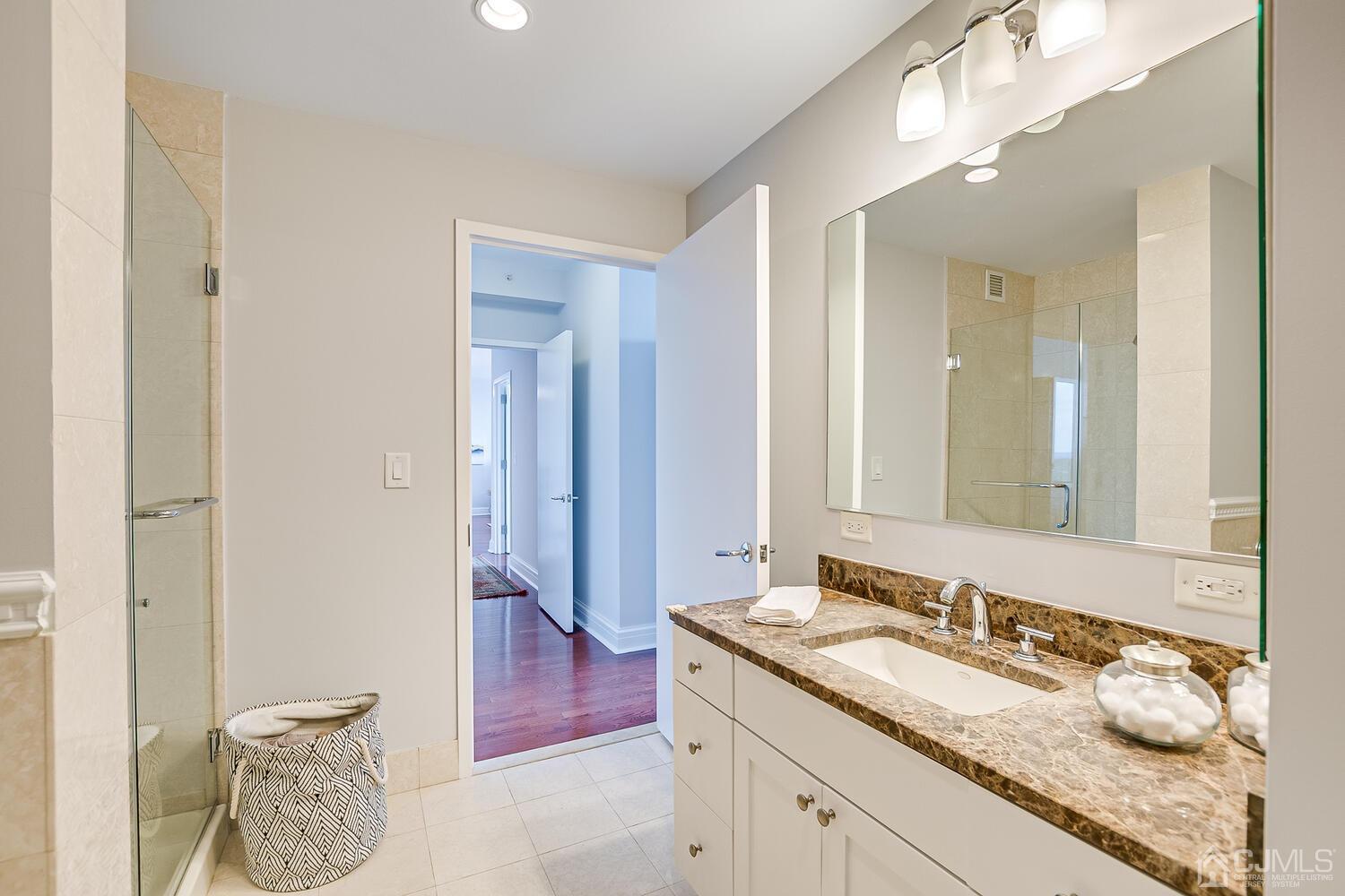 1 Spring Street, Unit 1806 New Brunswick, NJ 08901 - Photo 28 of 57 a bathroom with a granite countertop sink and a mirror