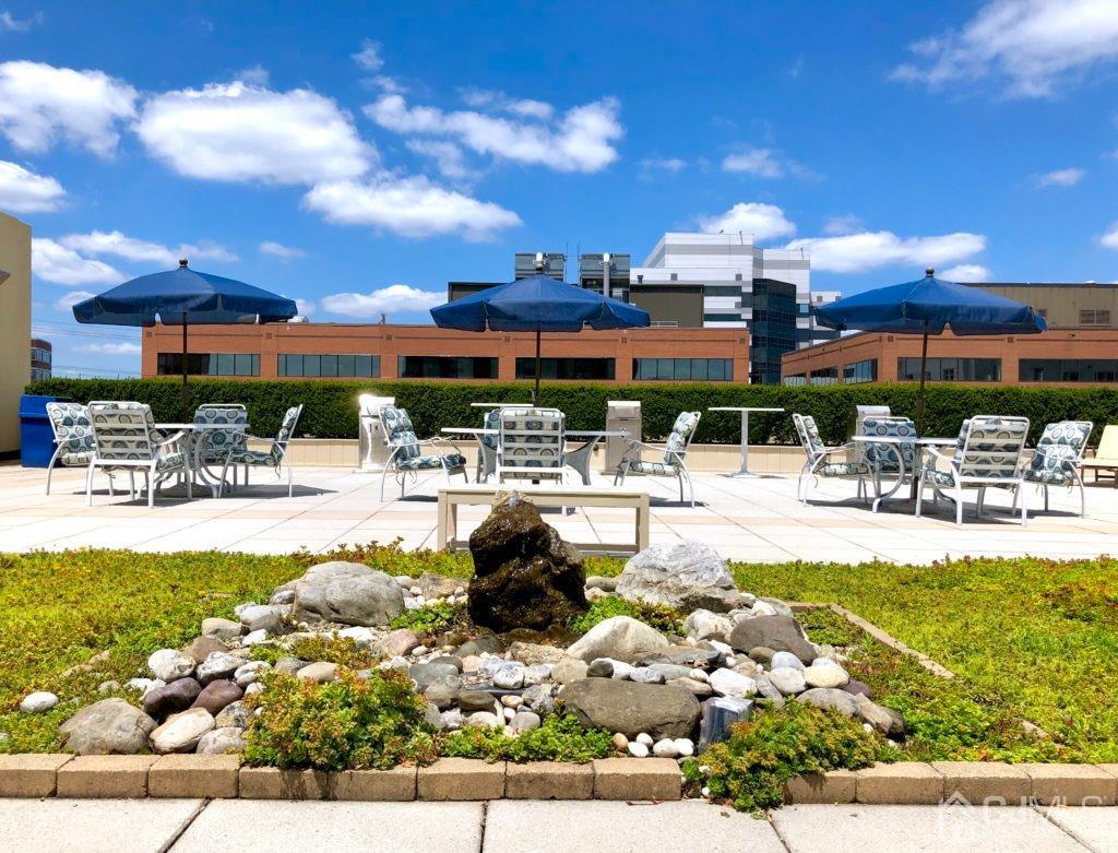 1 Spring Street, Unit 1806 New Brunswick, NJ 08901 - Photo 53 of 57 a swimming pool with outdoor seating and a garden
