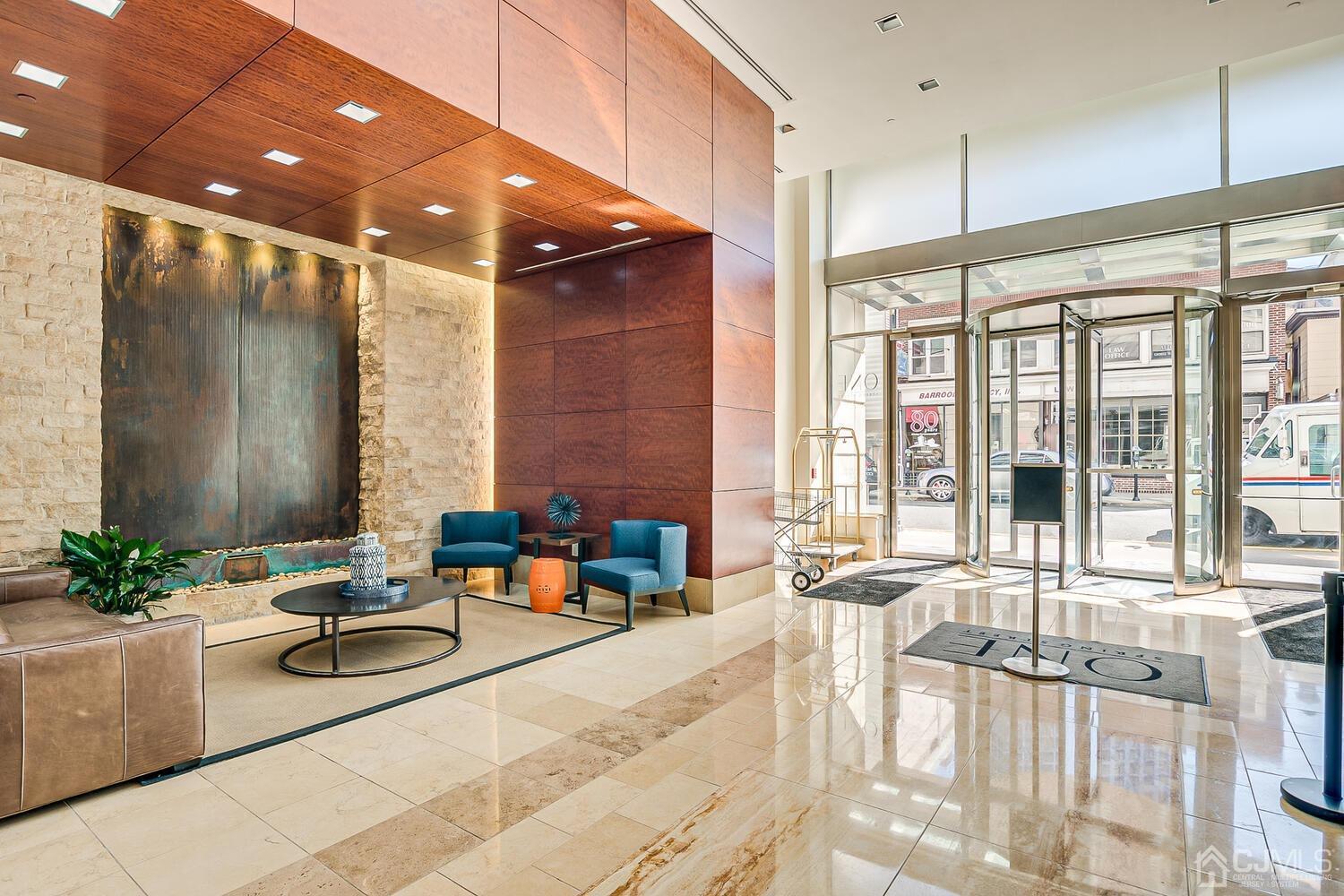 1 Spring Street, Unit 1806 New Brunswick, NJ 08901 - Photo 7 of 57 a lobby with a couch and potted plant