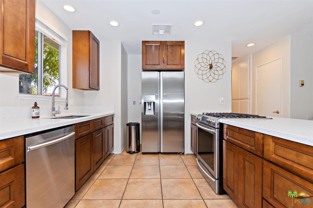 2802 North Chuperosa Road Palm Springs, CA 92262 - Photo 5 of 25 a kitchen with stainless steel appliances granite countertop a refrigerator and a sink