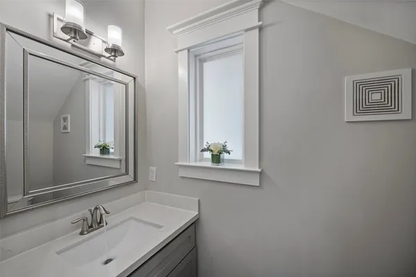 a bathroom with a sink vanity and a mirror