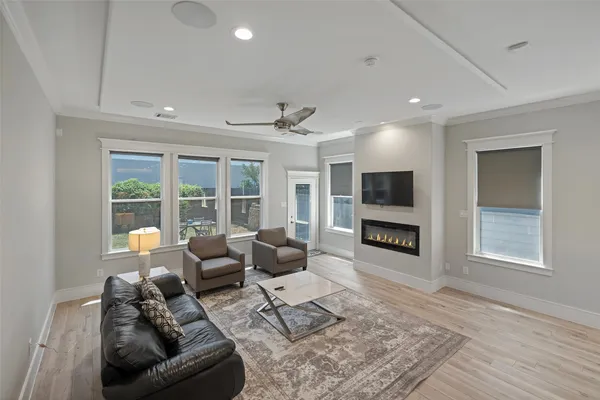 a living room with furniture a fireplace and a floor to ceiling window