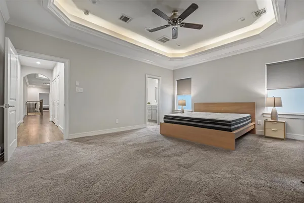 a spacious bedroom with a bed and a chandelier