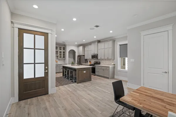 a kitchen with a table chairs refrigerator and microwave