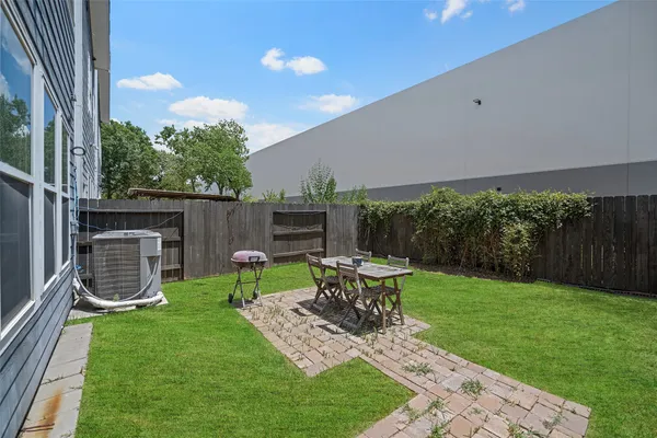 a view of a chair and table in backyard of the house
