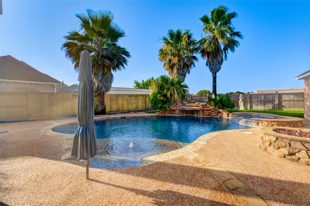 a view of a swimming pool with a chair and palm trees
