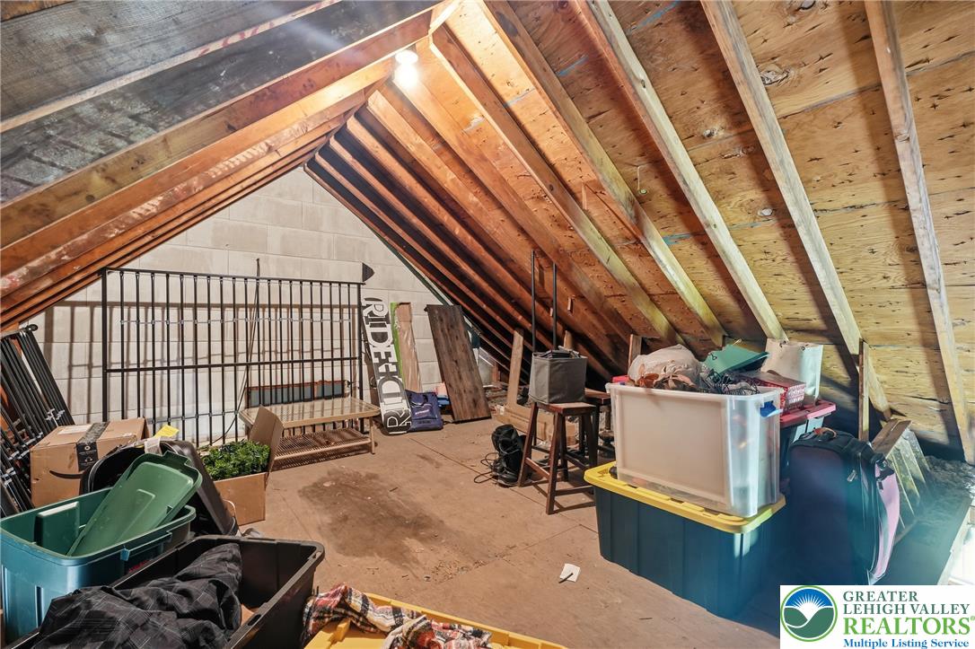 408 Maple Road Hellertown, PA 18055 - Photo 43 of 66 Exposed wooden rafters and concrete block walls define this unfinished attic storage space.