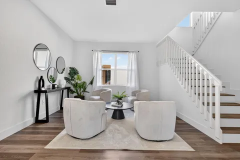 a dining room with wooden floor a chandelier a glass table and chairs