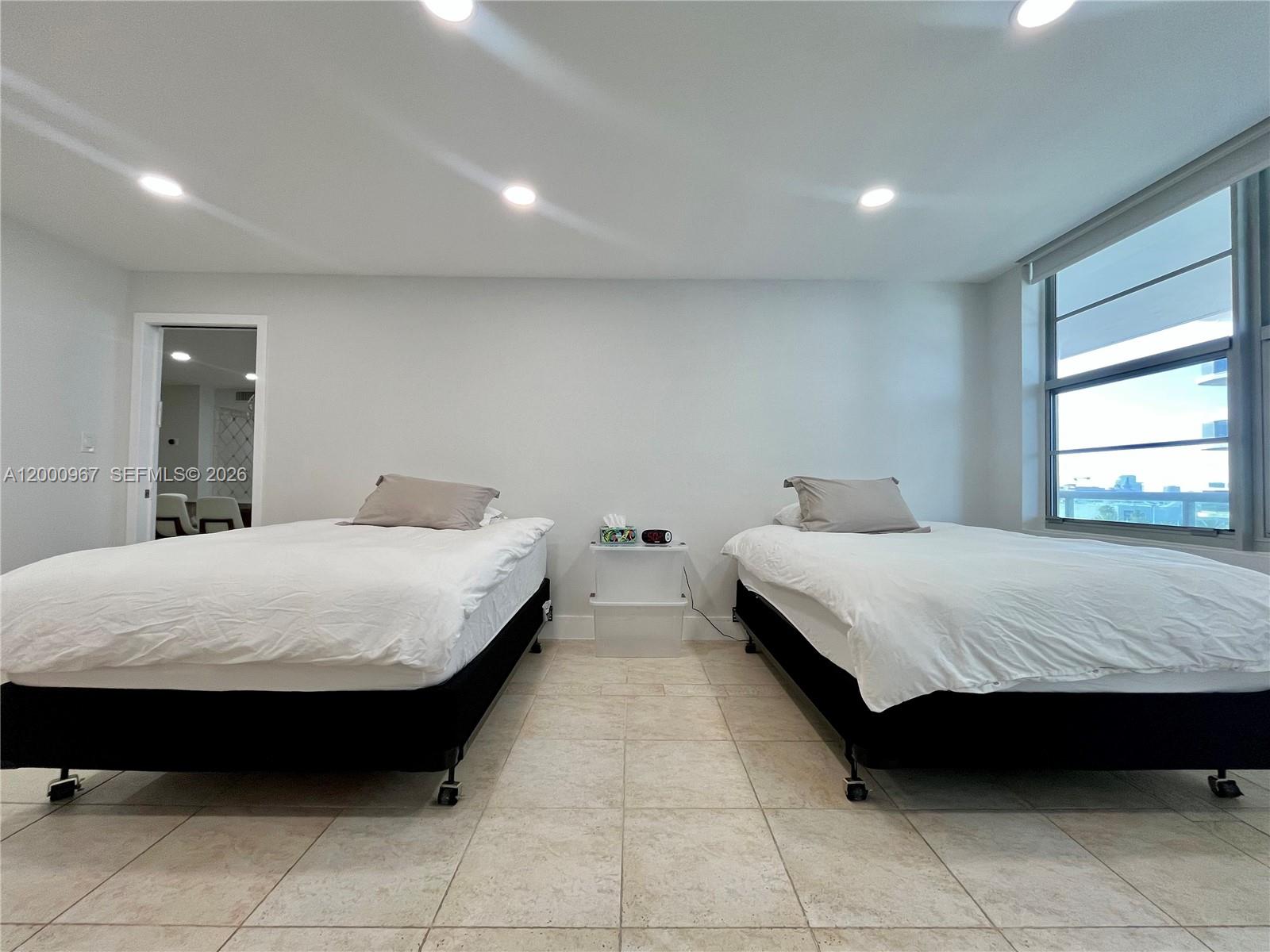 9511 Collins Avenue, Unit 811 Surfside, FL 33154 - Photo 11 of 29 a spacious bedroom with a bed and window