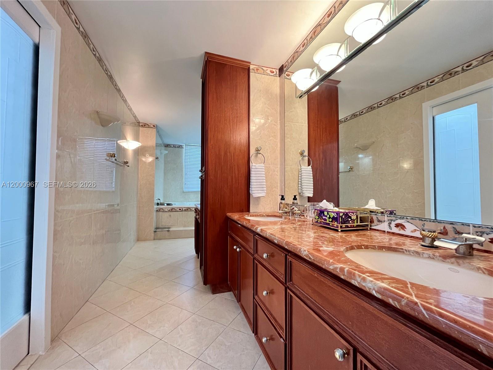 9511 Collins Avenue, Unit 811 Surfside, FL 33154 - Photo 12 of 29 a spacious bathroom with a granite countertop sink mirror and a shower