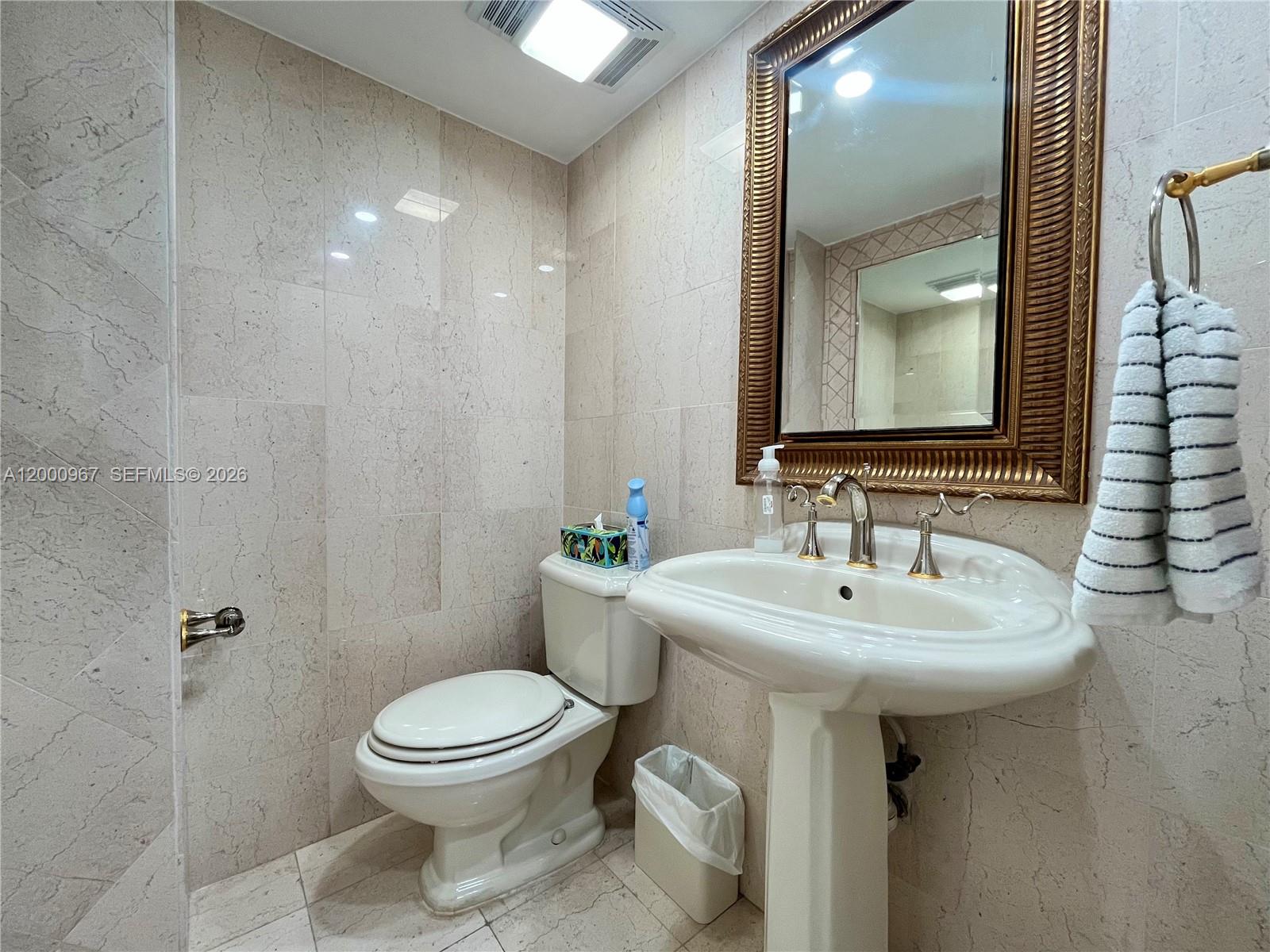 9511 Collins Avenue, Unit 811 Surfside, FL 33154 - Photo 20 of 29 a bathroom with a sink toilet and a mirror