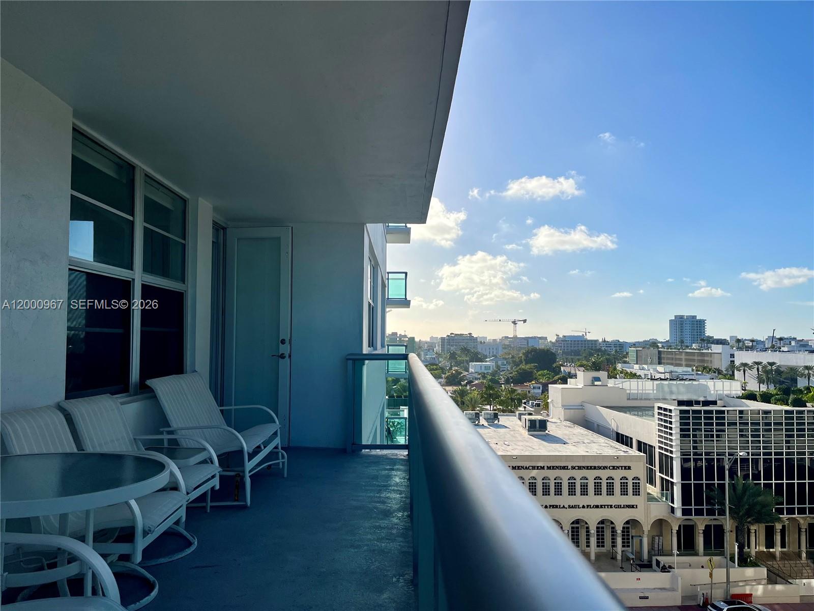 9511 Collins Avenue, Unit 811 Surfside, FL 33154 - Photo 21 of 29 a balcony with table and chairs