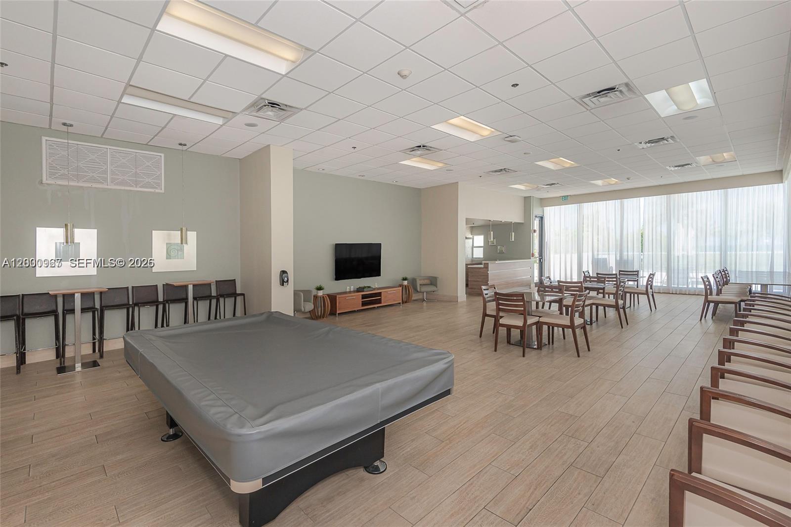 9511 Collins Avenue, Unit 811 Surfside, FL 33154 - Photo 27 of 29 a living room with furniture a flat screen tv and a table