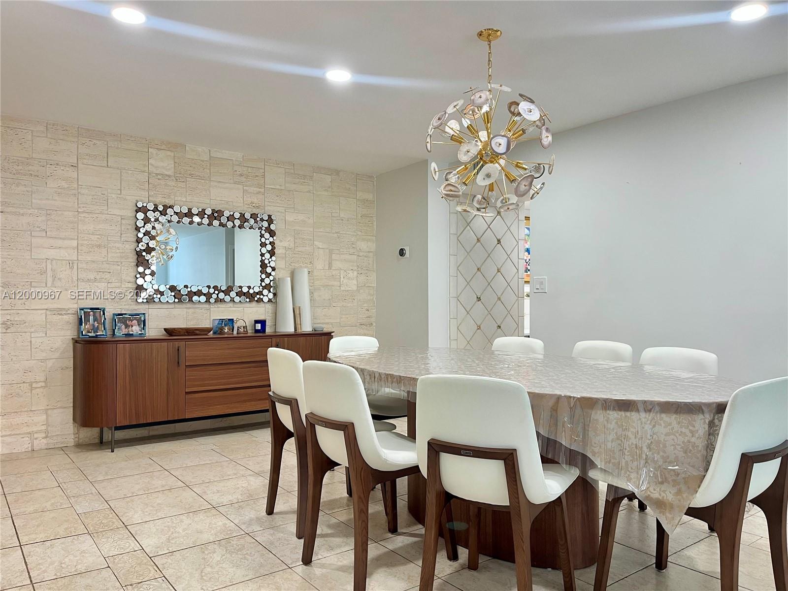 9511 Collins Avenue, Unit 811 Surfside, FL 33154 - Photo 4 of 29 a dining room with furniture and chandelier