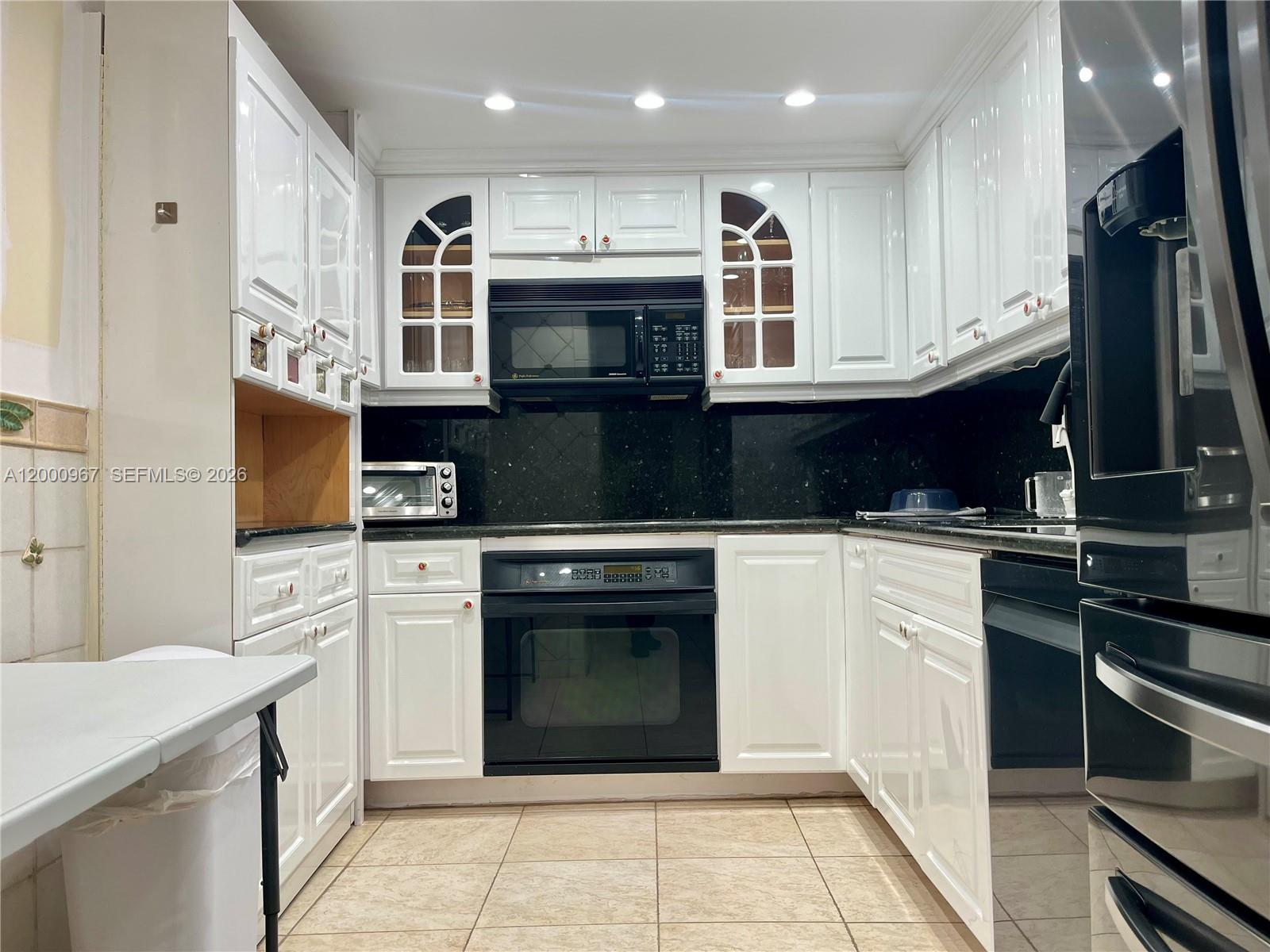 9511 Collins Avenue, Unit 811 Surfside, FL 33154 - Photo 6 of 29 a kitchen with stainless steel appliances granite countertop a stove and a refrigerator