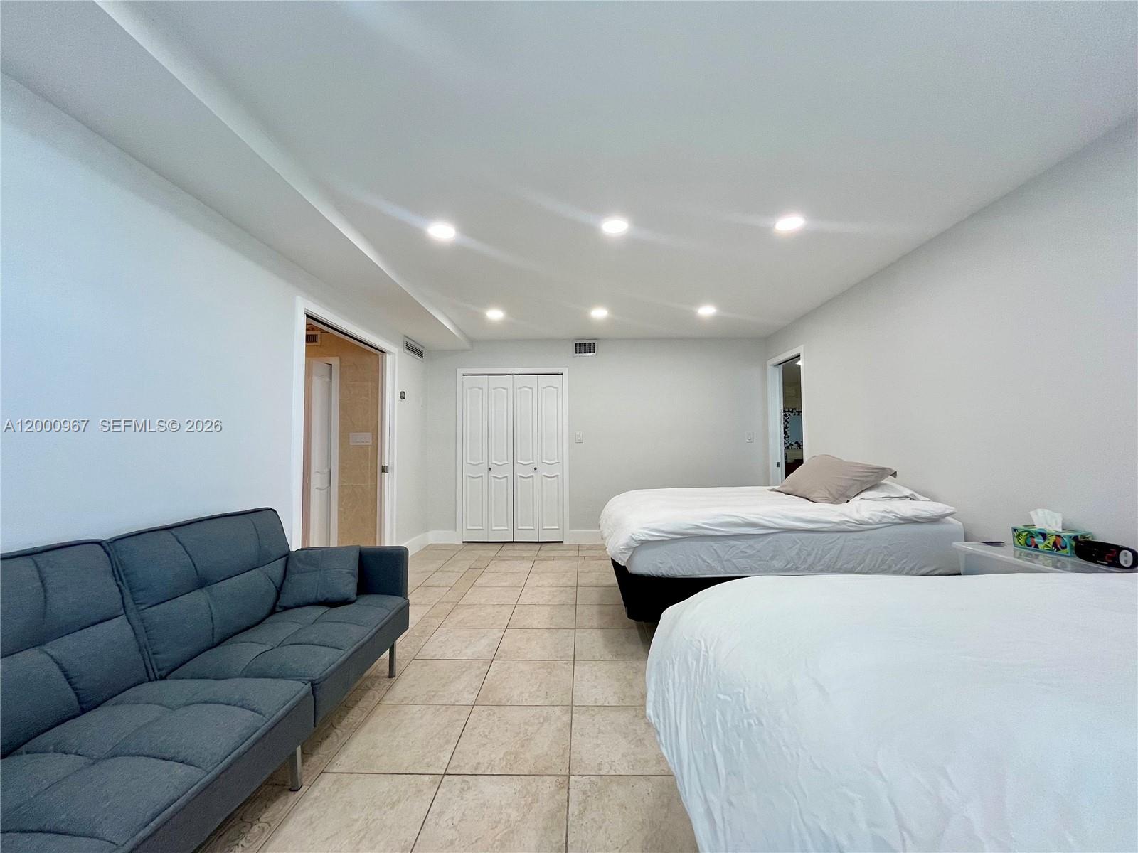 9511 Collins Avenue, Unit 811 Surfside, FL 33154 - Photo 9 of 29 a large bedroom with a bed and a couch