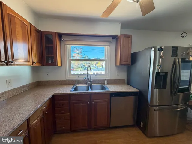a kitchen with granite countertop wooden cabinets and a sink