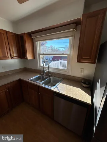 a kitchen with stainless steel appliances granite countertop a sink a stove cabinets and wooden floor