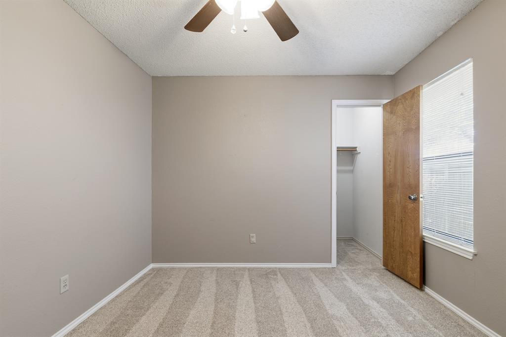 6612 Patsy Lane Watauga, TX 76148 - Photo 21 of 32 Bedroom featuring neutral-toned walls, patterned carpeting, a ceiling fan with integrated lighting, a window with blinds, and an open closet with shelving and wood-finish flooring