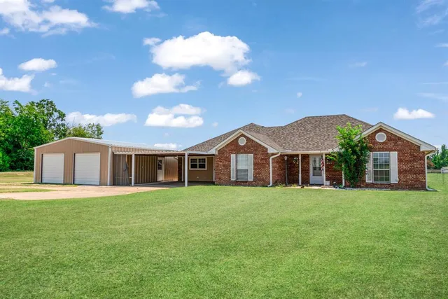 a white house with a big yard and large trees