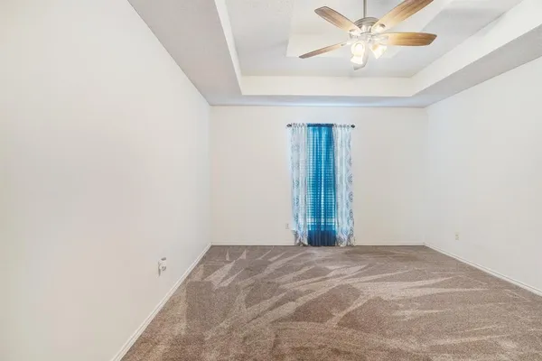 an empty room with a chandelier fan and closet