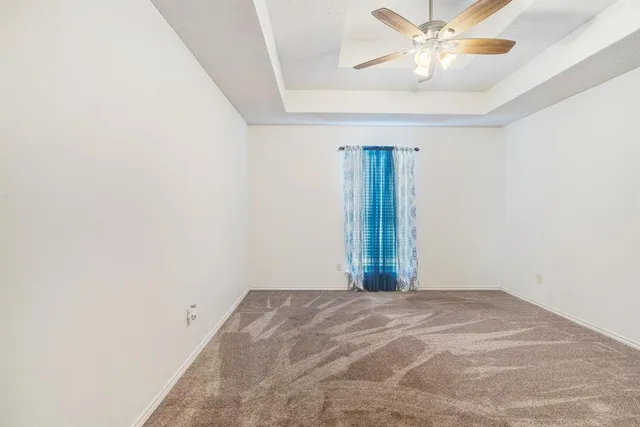 an empty room with a chandelier fan and closet