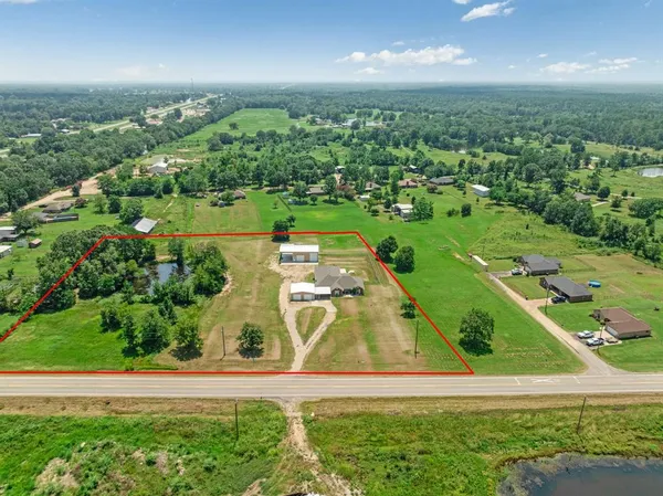 an aerial view of a residential houses with yard and green space