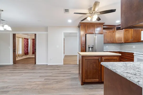 a kitchen with kitchen island granite countertop wooden cabinets and white appliances