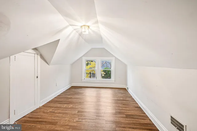 a view of a hallway with wooden floor and ceiling fan