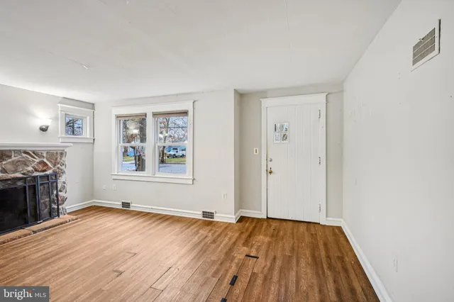 a view of empty room with wooden floor and fireplace