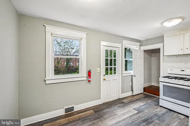 a view of a kitchen with wooden floor and electronic appliances