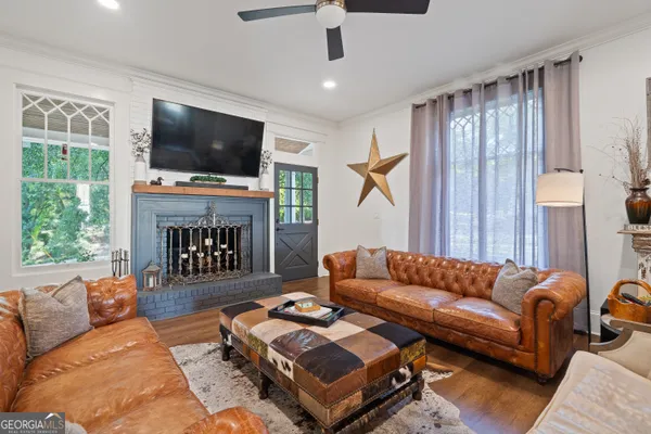 a living room with furniture ceiling fan and a window