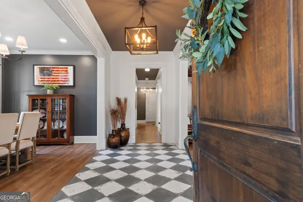 a view of a hallway with a livingroom with furniture and windows