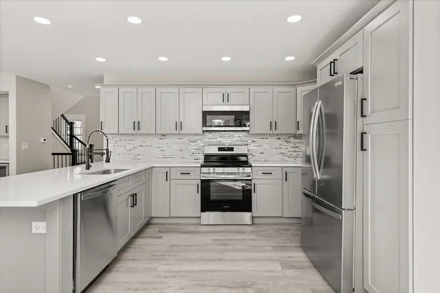 a kitchen with granite countertop a refrigerator stove and sink