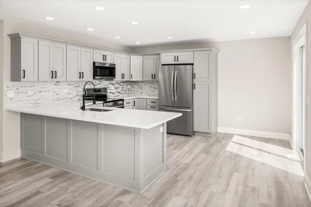 a kitchen with kitchen island a sink stainless steel appliances and cabinets