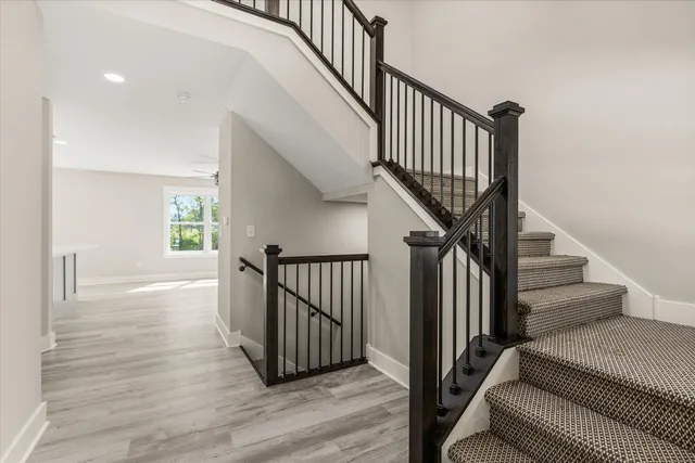 a view of staircase with wooden floor and a rug