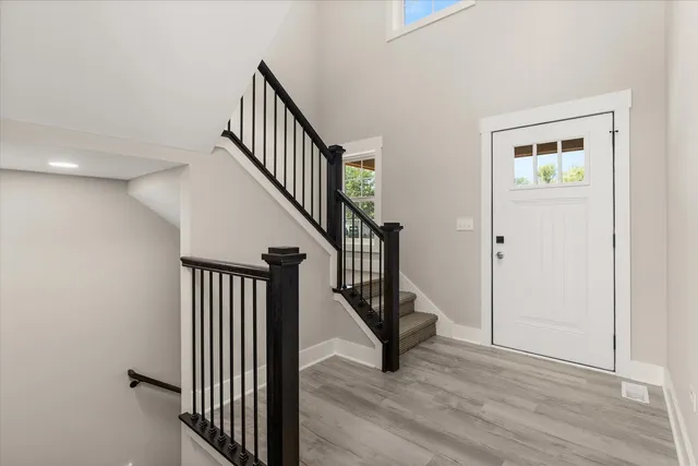 a view of a hallway with wooden floor and entryway