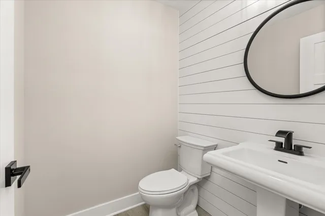 a bathroom with a toilet a sink and mirror