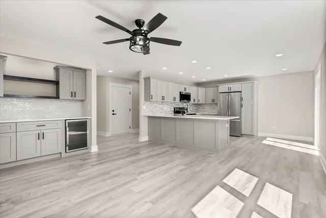 a view of a kitchen with kitchen island a sink stainless steel appliances and cabinets