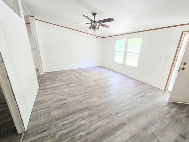 an empty room with wooden floor and window