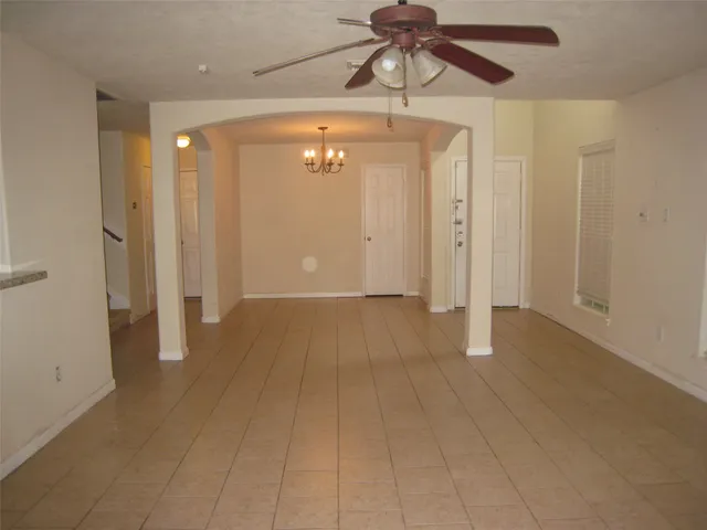 a view of a hallway with a chandelier fan and wooden floor