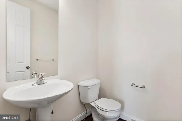 a bathroom with a sink a toilet and mirror