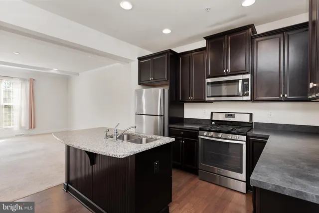 a kitchen with a sink stainless steel appliances and cabinets